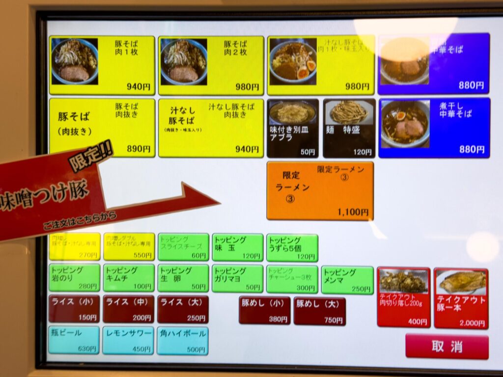 ラーメン弍豚の食券機。豚そば、汁なし豚そば、味噌つけ豚などのメニューが並ぶ