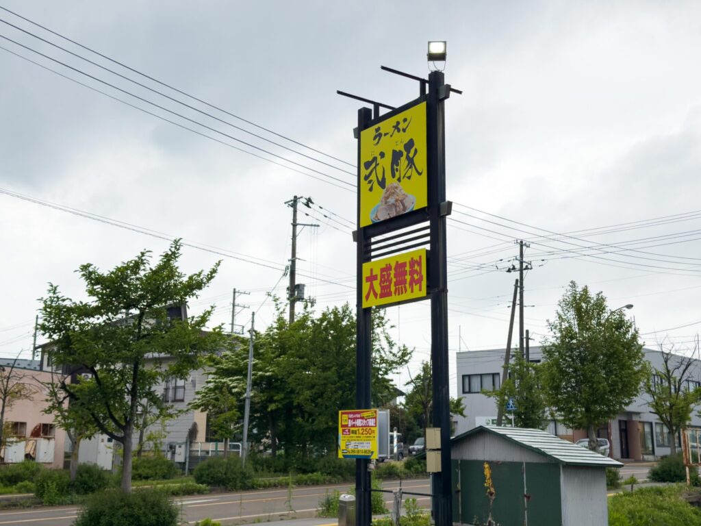 黄色い看板が目印のラーメン弍豚小千谷店の外観