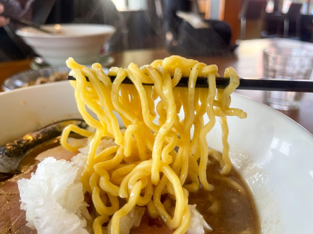 黄色い中太ちぢれ麺が煮干しスープをしっかり持ち上げる、食べごたえのある麺リフト