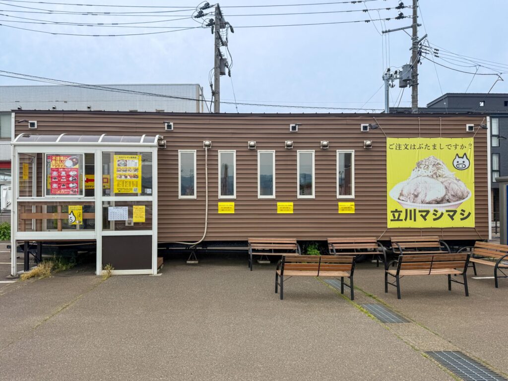 立川マシマシ長岡店の外観。プレハブ風の店舗に大きなラーメン看板が目印