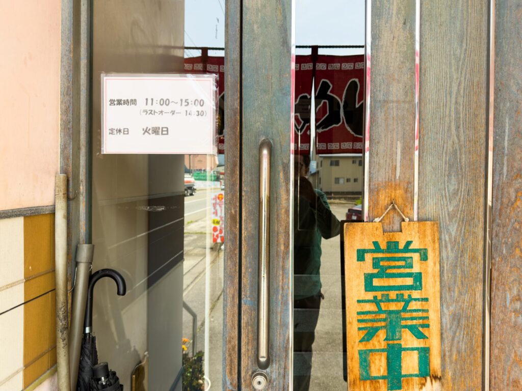 すすり家の営業時間と定休日を示す店頭の案内紙