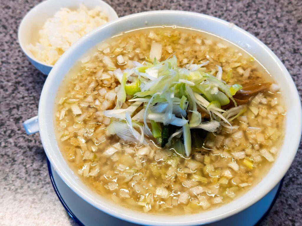 玉ねぎがたっぷりのった正油ラーメンと無料の小ライス