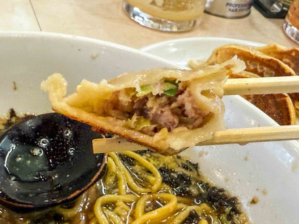 肉汁あふれる餃子の断面と背脂醤油ラーメンのスープ