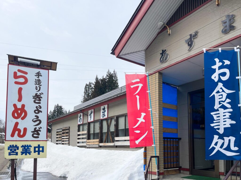 松代にある食堂あずまの外観。赤いラーメン旗と青いお食事処ののぼりが目印